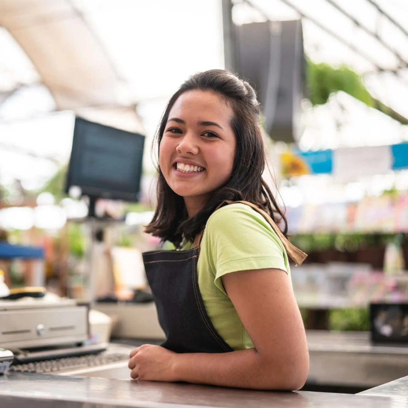 Operadora de caixa sorrindo no ponto de venda.
