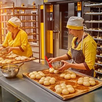 Equipe de padaria preparando pães na produção.